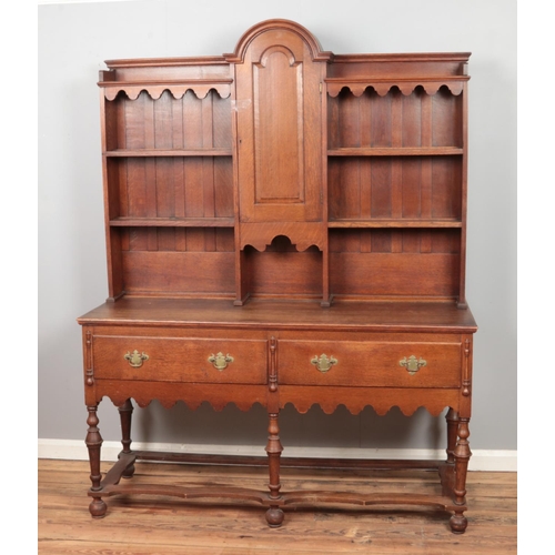 441 - A carved oak dresser with domed top and turned supports.