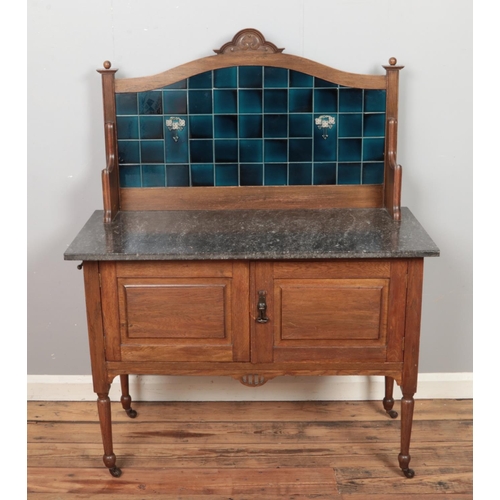 451 - A marble topped wash stand featuring blue tiled back.