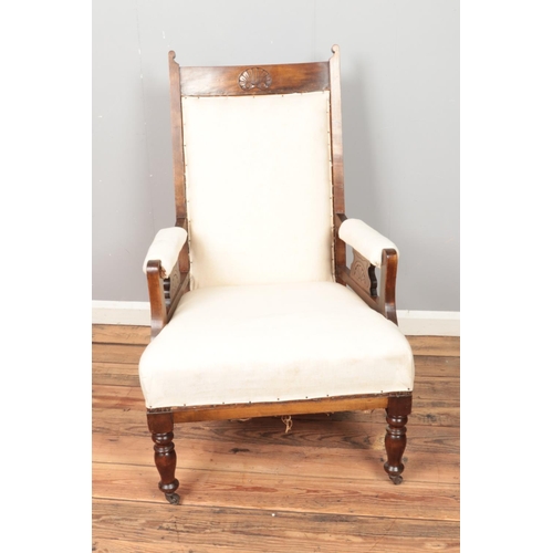 452 - A mahogany cream upholstered arm chair on castors.