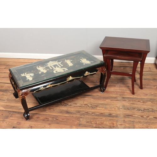 455 - A decorative glass topped coffee table featuring carved figures and feet along with a nest of two ta... 