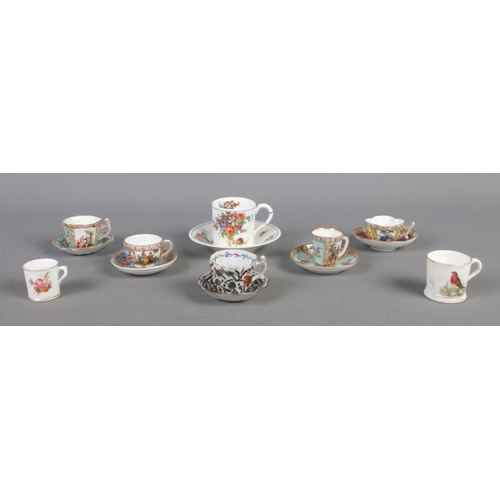 119 - Six twentieth century miniature porcelain cups and saucers, together with two additional miniature c... 