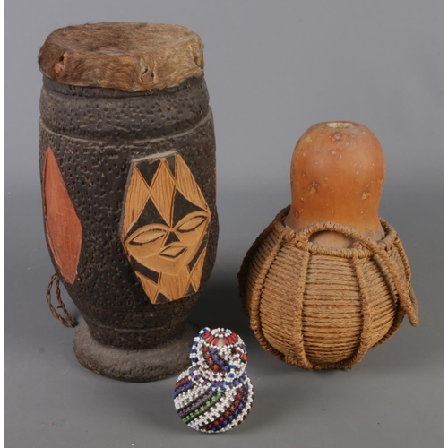 120 - A carved African animal hide skin drum along with two gourds. Including beadwork example.