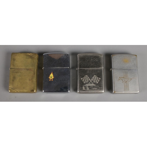 123 - Four Zippo lighters, including brass and racehorse examples.