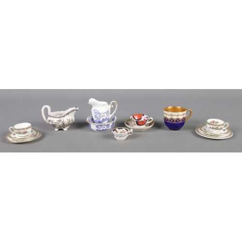 128 - A quantity of miniature ceramics, to include Coalport willow washbowl and jug and Ming Rose trios an... 