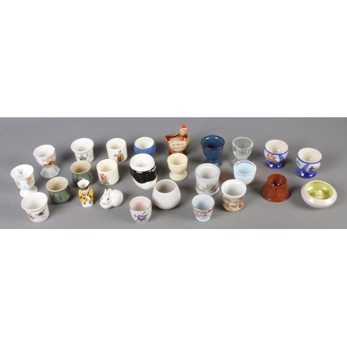 132 - A collection of egg cups and small figures including Bunnykins, Wedgwood, Lomonsov and Poole example... 