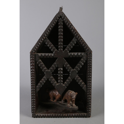 133 - A Black Forest style model of a building, featuring carved detailing and containing two bears suspen... 