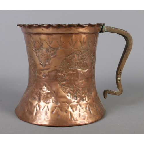 144 - A large hammered copper tankard with wavy edge and beaten decoration depicting deer and flowers. 17c... 