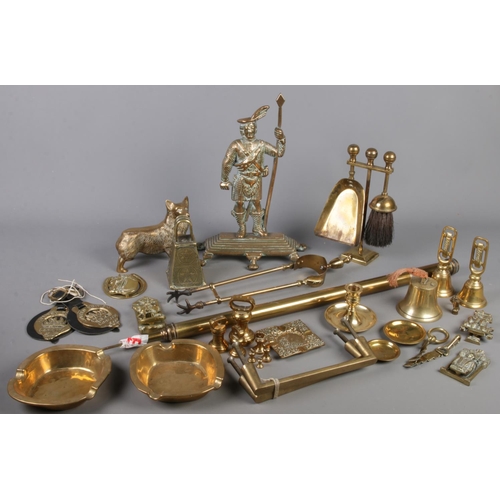 177 - A box of brassware. Includes fireside accessories, Corgi dog figure, door knockers, horse brasses, w... 