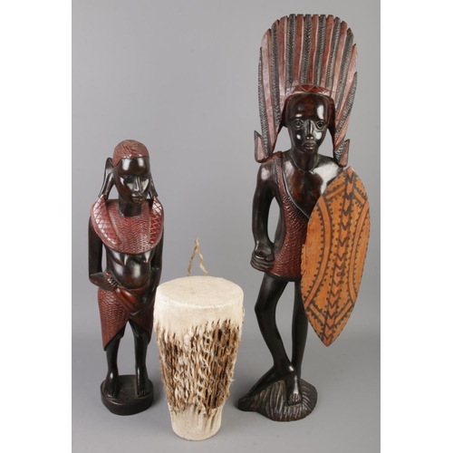 13 - Two carved hardwood African figures along with an animal hide drum. Tallest figure 66cm tall.