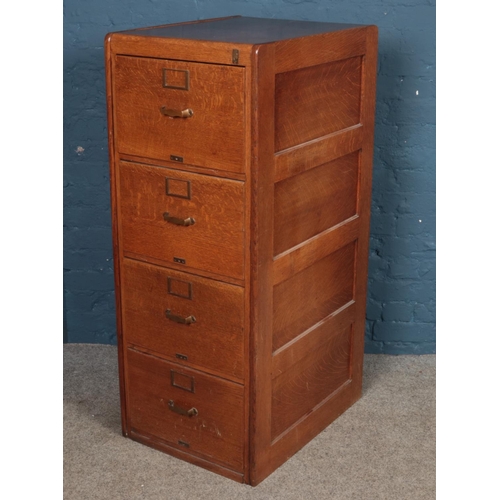 499 - A panelled oak four drawer filing cabinet. (131cm x 53cm x 67cm)