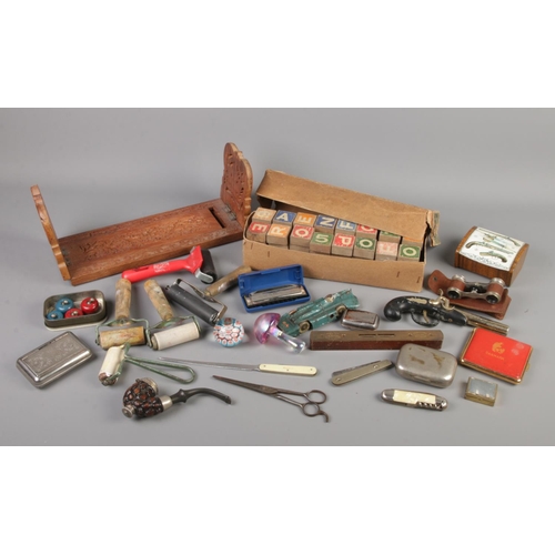 31 - A box of collectables. Includes pipe, folding knives, ink rollers, book trough, German tinplate car ... 