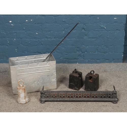 235 - A collection of metalwares to include fire fender, Walls ice cream tin and cast iron weights.