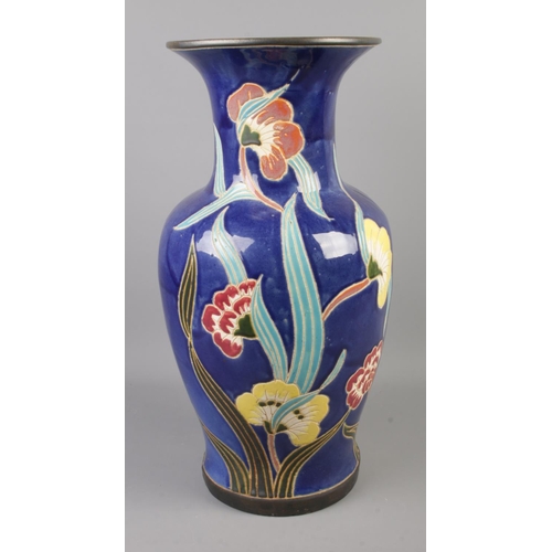 243 - A painted ceramic floor vase featuring floral decoration. Approx. 52cm tall.