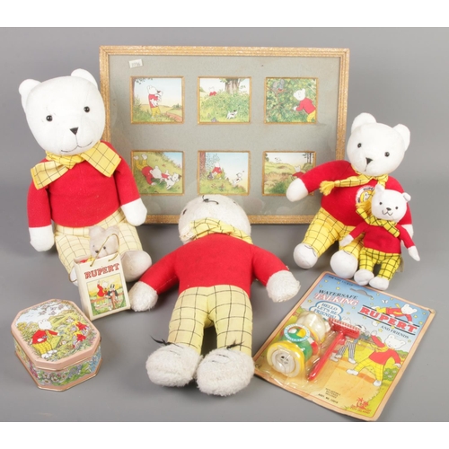 41 - A quantity of Rupert Bear collectables. Includes teddy bears, boxed toy, tin, print, etc.