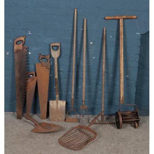 309 - A quantity of mostly garden tools. Includes shovel, rake, hoe, old lawn mower, etc.