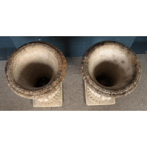 319 - A large pair of cast concrete Medici style garden urns, with classical decoration, on fluted socle b... 