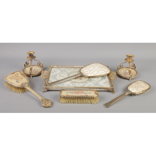 59 - A collection of dressing table items, to include raised stand, hand mirrors and brushes.