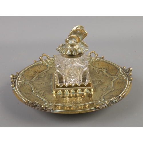 64 - A decorative oriental style brass inkwell featuring insect top.