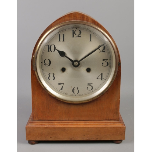 73 - A mahogany mantle clock, with Arabic numeral dial raised on four small turned feet. 31cm high.