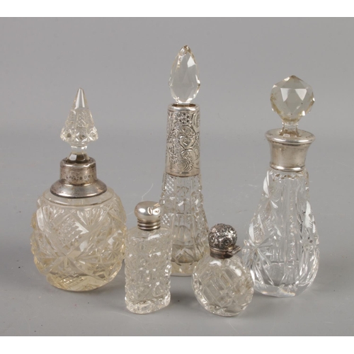 409 - Five silver mounted cut glass scent bottles.