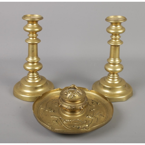 89 - A brass ink well decorated with exotic birds along with a pair of brass ejector candlesticks.