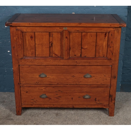 436 - A stained pine lift top blanket box over two drawers, by The Irish Coast Collection, featuring shell... 