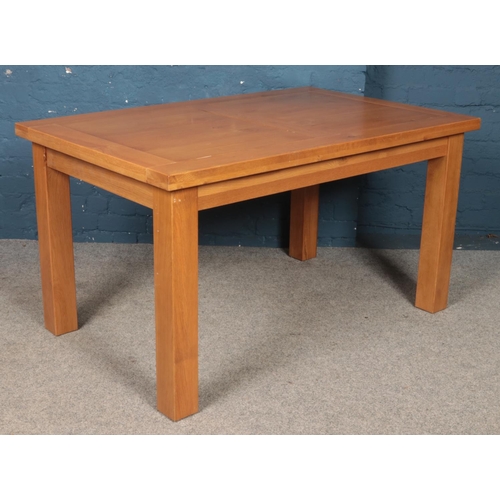 440 - A modern oak veneered dining table. Height: 77cm, Width: 140cm, Depth: 90cm.