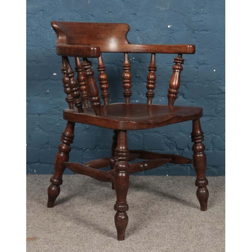 477 - An oak smokers bow arm chair, with spindle supports.