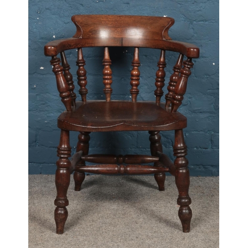 477 - An oak smokers bow arm chair, with spindle supports.