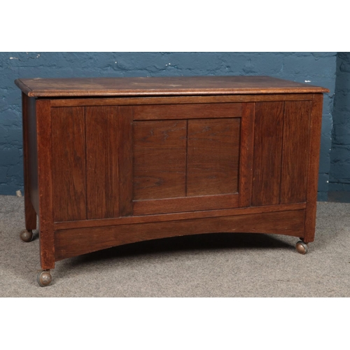 478 - A panelled oak blanket box, raised on casters. Height:61cm, Width: 100cm, Depth: 46cm.