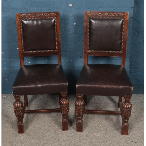 481 - A pair of studded leather chairs featuring carved floral decoration to legs.