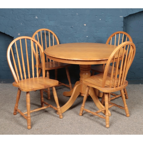 491 - A circular pine table, with four chairs.