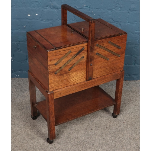 494 - An oak cantilever sewing box with contents.