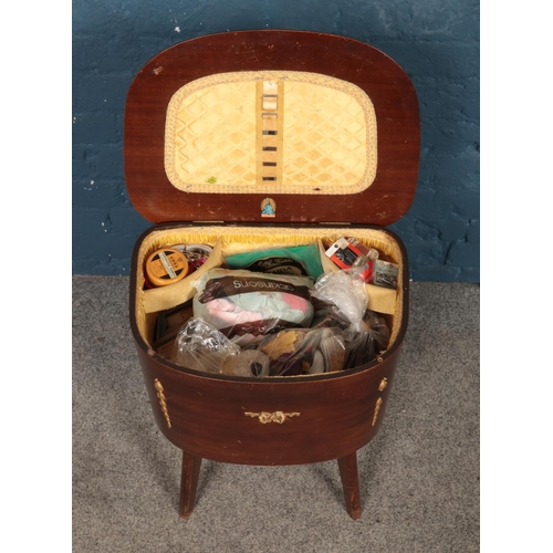 495 - A mahogany lift top sewing box and contents, produced by Morco. 55cm high.