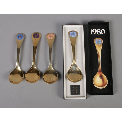 344 - Four Georg Jensen silver gilt year spoons featuring floral enamel decoration. Includes years 1972, 1... 