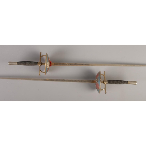 157 - A pair of fencing swords with coloured decoration. CANNOT POST OVERSEAS