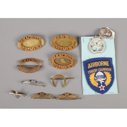 19 - A quantity of military cap badges and pins including the Parachute Regiment and Glider Pilot regimen... 