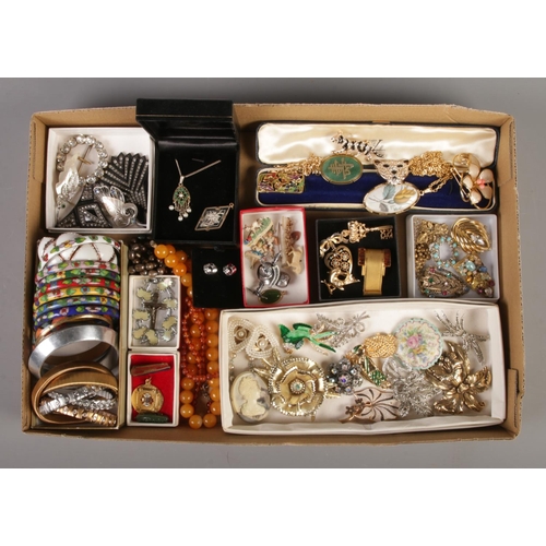 65 - A tray containing an assortment of costume jewellery, including bangles, brooches, beaded necklaces ... 