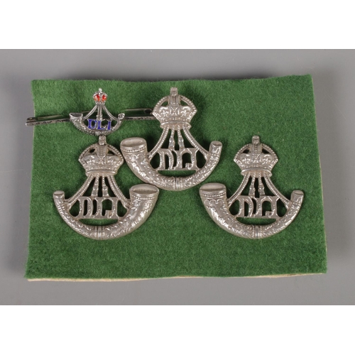 296 - Three Durham Light Infantry cap badges along with bar brooch, all stamped Sterling to reverse. Total... 