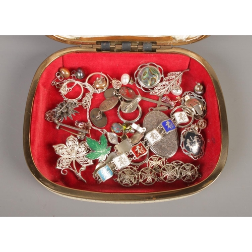 371 - A cream jewellery box containing an assortment of silver jewellery. To include locket, enamel bracel... 