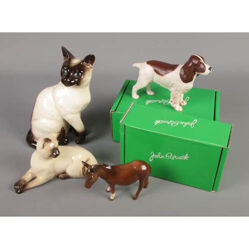 396 - A collection of Beswick figures including Siamese cats, boxed Springer Spaniel and boxed Donkey.