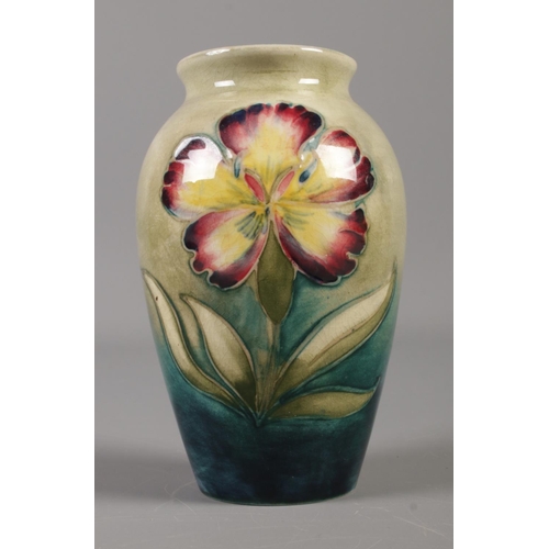 400 - A Moorcroft orchid vase with blue green glaze. Height 10.5cm.