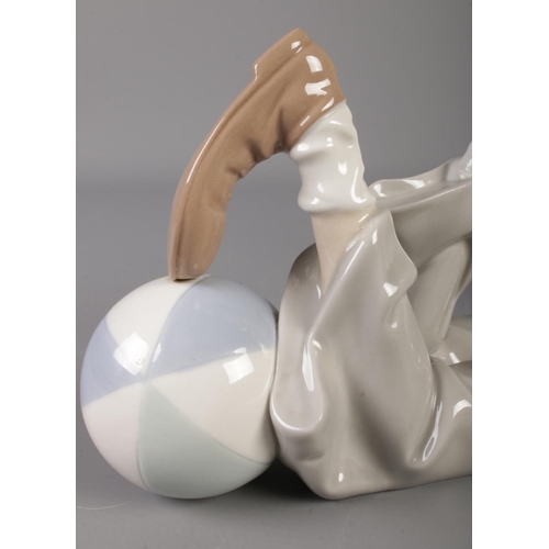 421 - A Lladro ceramic reclining clown, with ball at his feet. Length: 36cm.