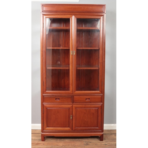 427 - A Chinese hardwood glazed cabinet with drawer and cupboard base. Height 198.5cm, Width 92cm, Depth 4... 