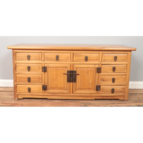 434 - An Asian hardwood low sideboard. Height 57cm, Width 131cm, Depth 43cm.