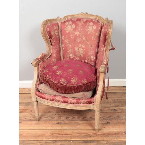 435 - An upholstered carved pitch pine chair.