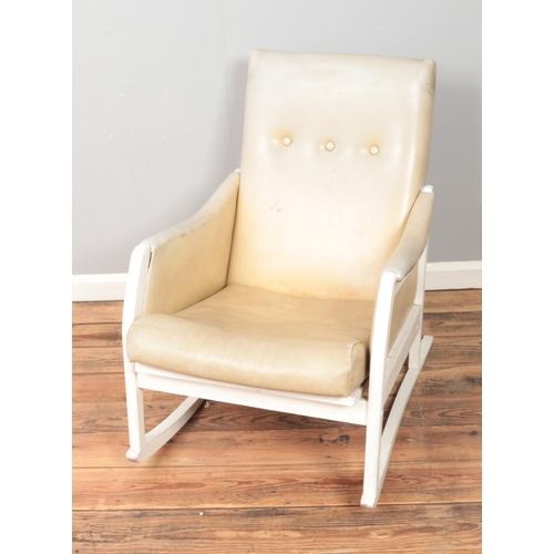 436 - A painted white leather rocking chair.