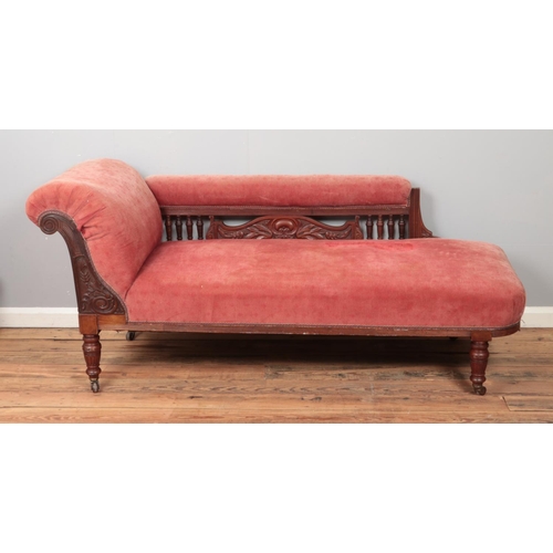 449 - A carved mahogany chaise longue raised on castors.