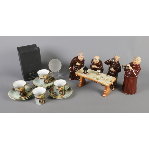 146 - A ceramic Monk set around a tavern table, Nippon hand painted cups and saucers and boxed crystal ten... 