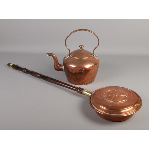 141 - A Victorian copper kettle along with a copper bed warming pan with Yorkshire rose decoration.